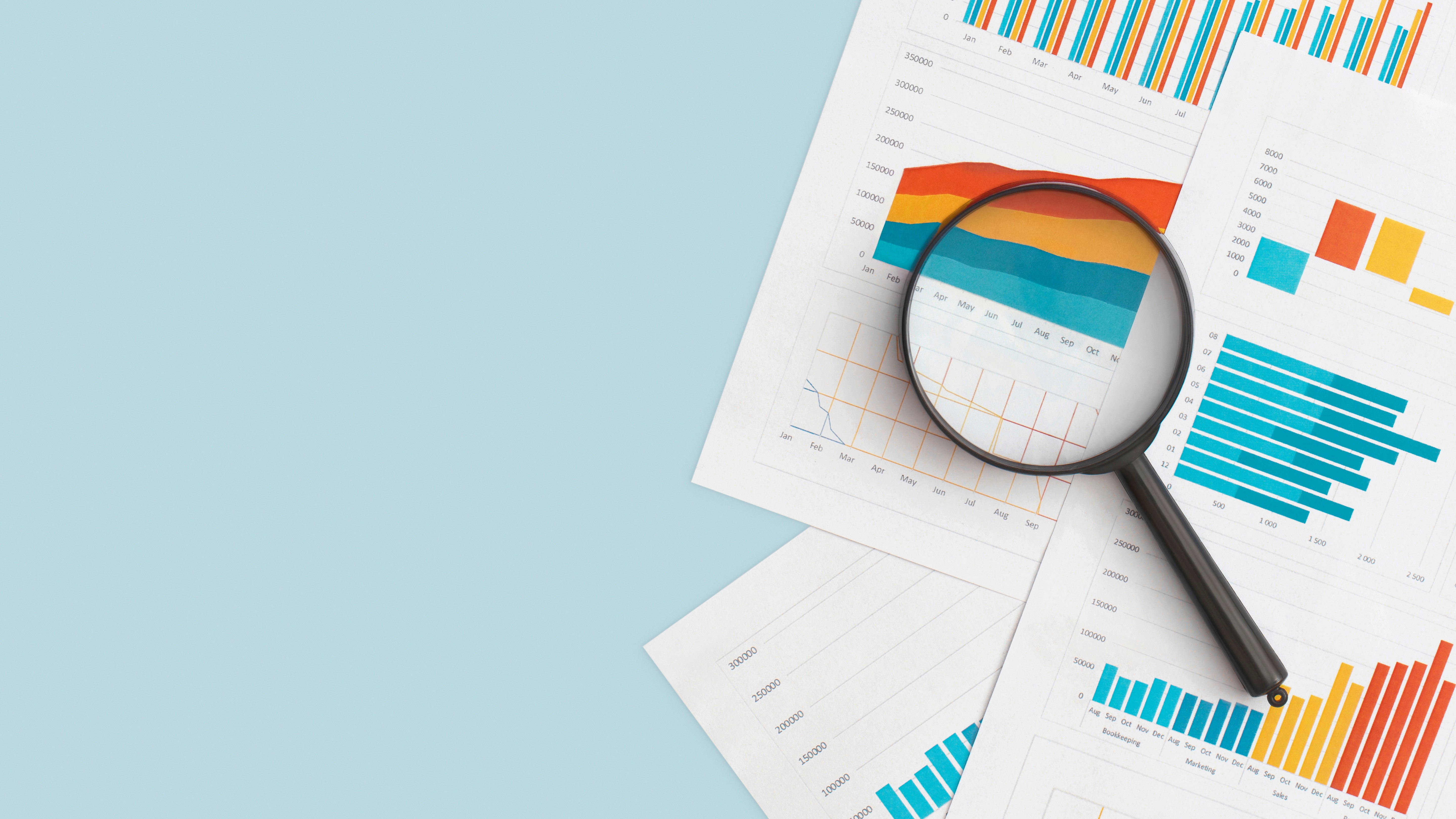 Diagram, tabeller och förstoringsglas på bordet